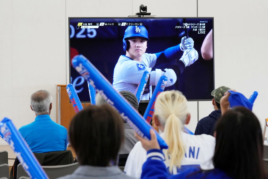 People watch Shohei Ohtani of the Los Angeles Dodgers during Game 4 of the baseball World Series between the Dodgers and the New York Yankees during a public viewing event in Ohtani