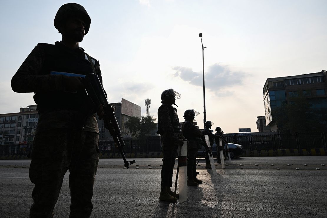 Paramilitary soldiers stand guard at a blocked road leading towards the Red Zone area ahead of a protest rally by jailed former prime minister Imran Khan