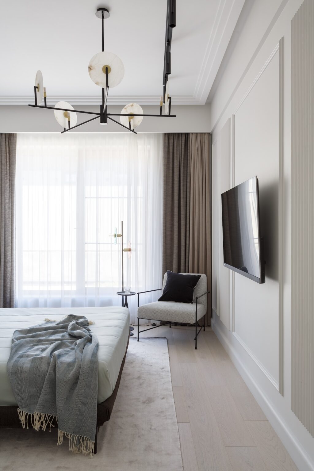 neutral themed bedroom with wall mounted tv